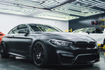 BMW sits in a garage alongside other cars