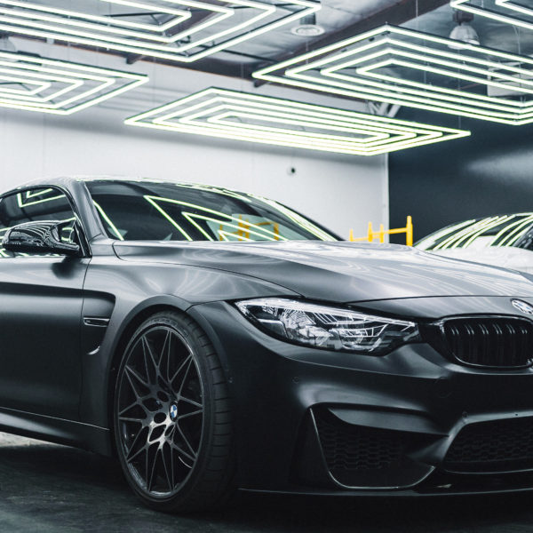 BMW sits in a garage alongside other cars