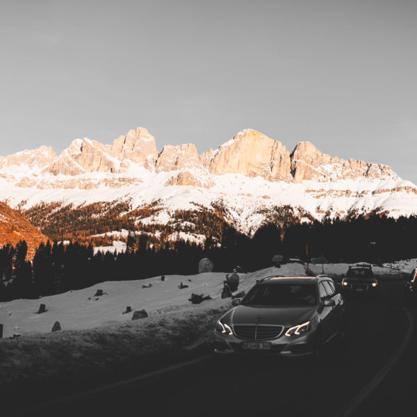 Cars drive through a snowy mountain road