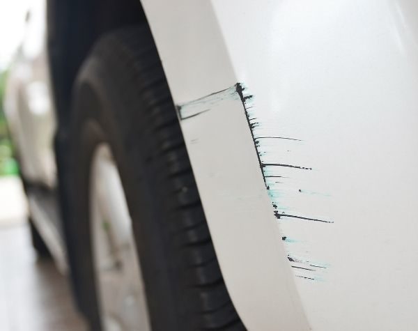 A photo of a white car focusing on the scratched part