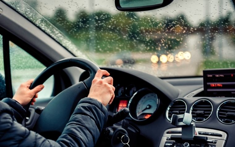 A person driving a car on a rainy day