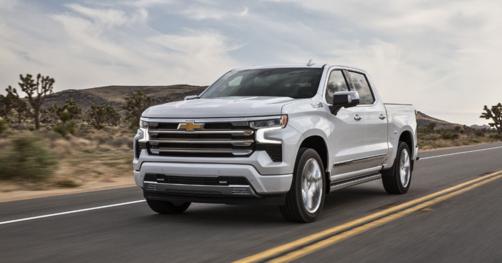 A white Chevy Silverado truck driving through the desert.