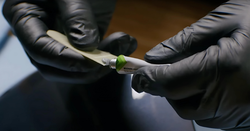 Gloved hands apply the TouchUpDirect Scratch & Chip putty to the spreader. 