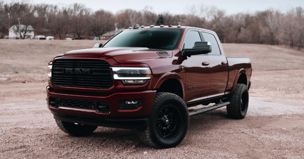 A red RAM Pickup parked near a forest.