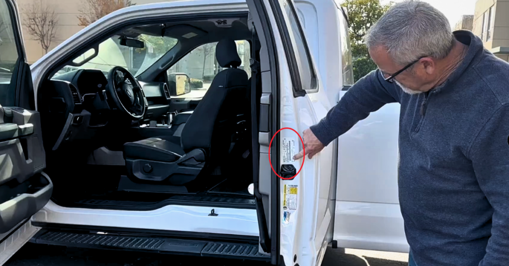 A man points out the color code label on a white truck.