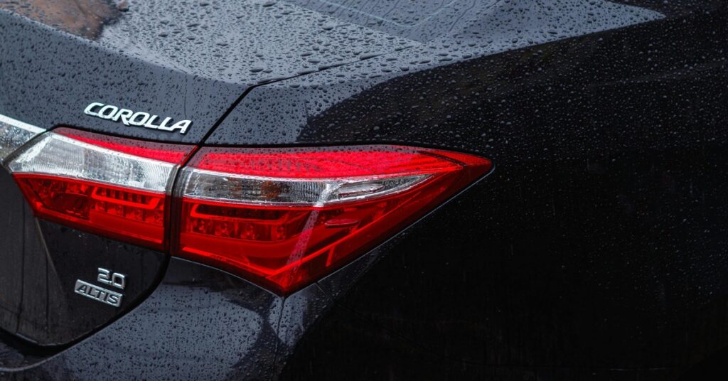 The back nameplate of a black Toyota Corolla.