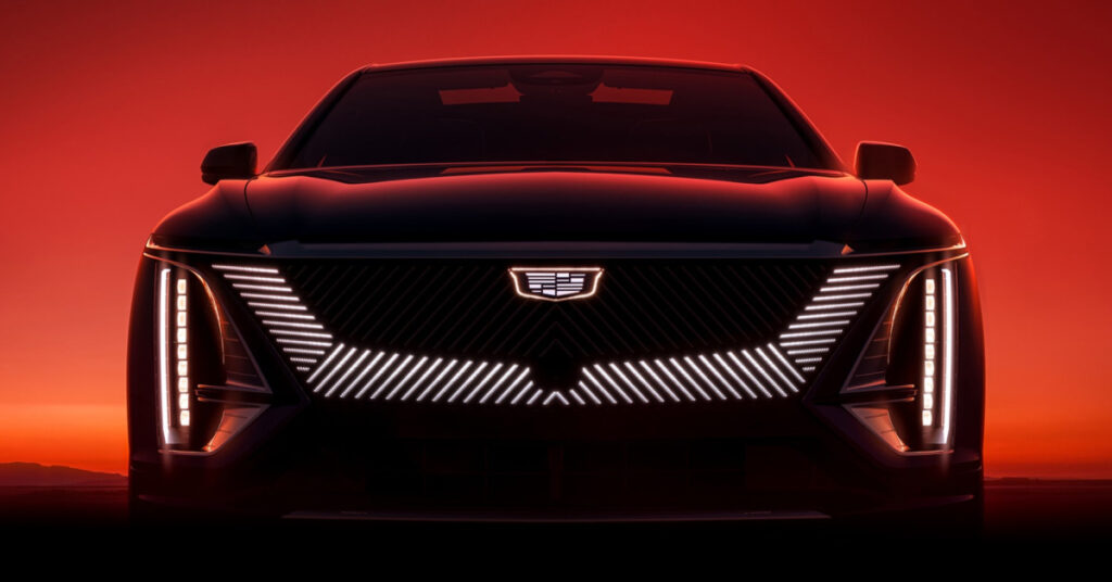 The front of a 2023 Cadillac LYRIQ EV bathed in ominous red and orange light.